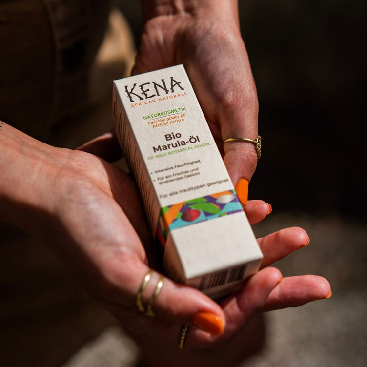 Bio Marulaoel | KENA African Naturals Zuckerrohrkarton Umverpackung in Händen gehalten