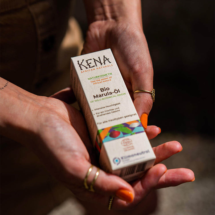 Bio Marulaöl von KENA African Naturals nachhaltige Produktverpackung wird in den Händen gehalten 