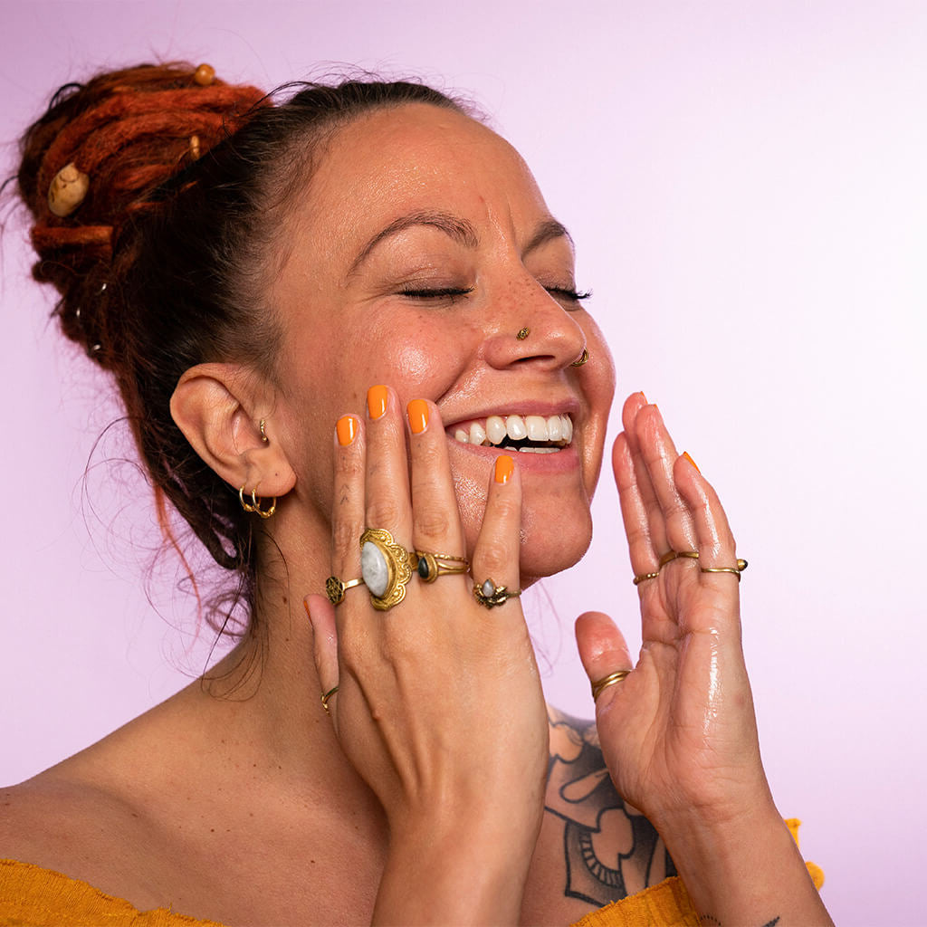 Bio Marulaöl von KENA African Naturals Anwendung im Gesicht von strahlender Frau